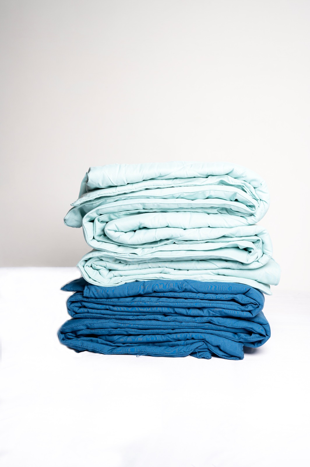 Folded comforters in teal and blue