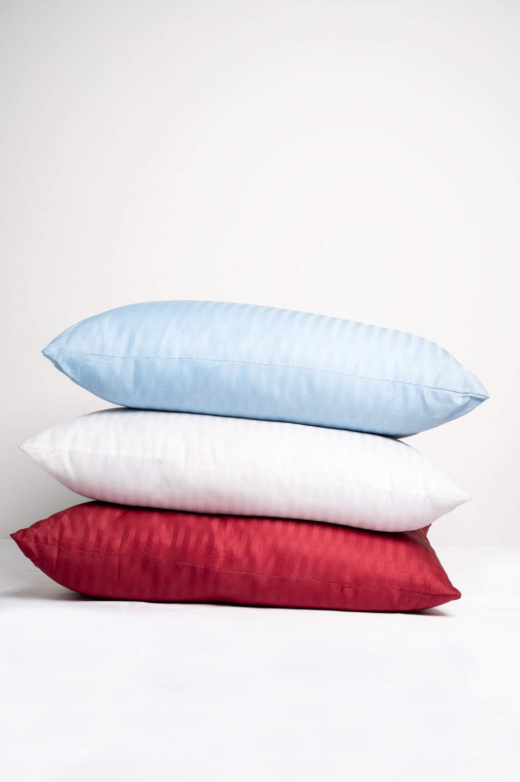 Stack of striped sateen pillows in blue, white, and red