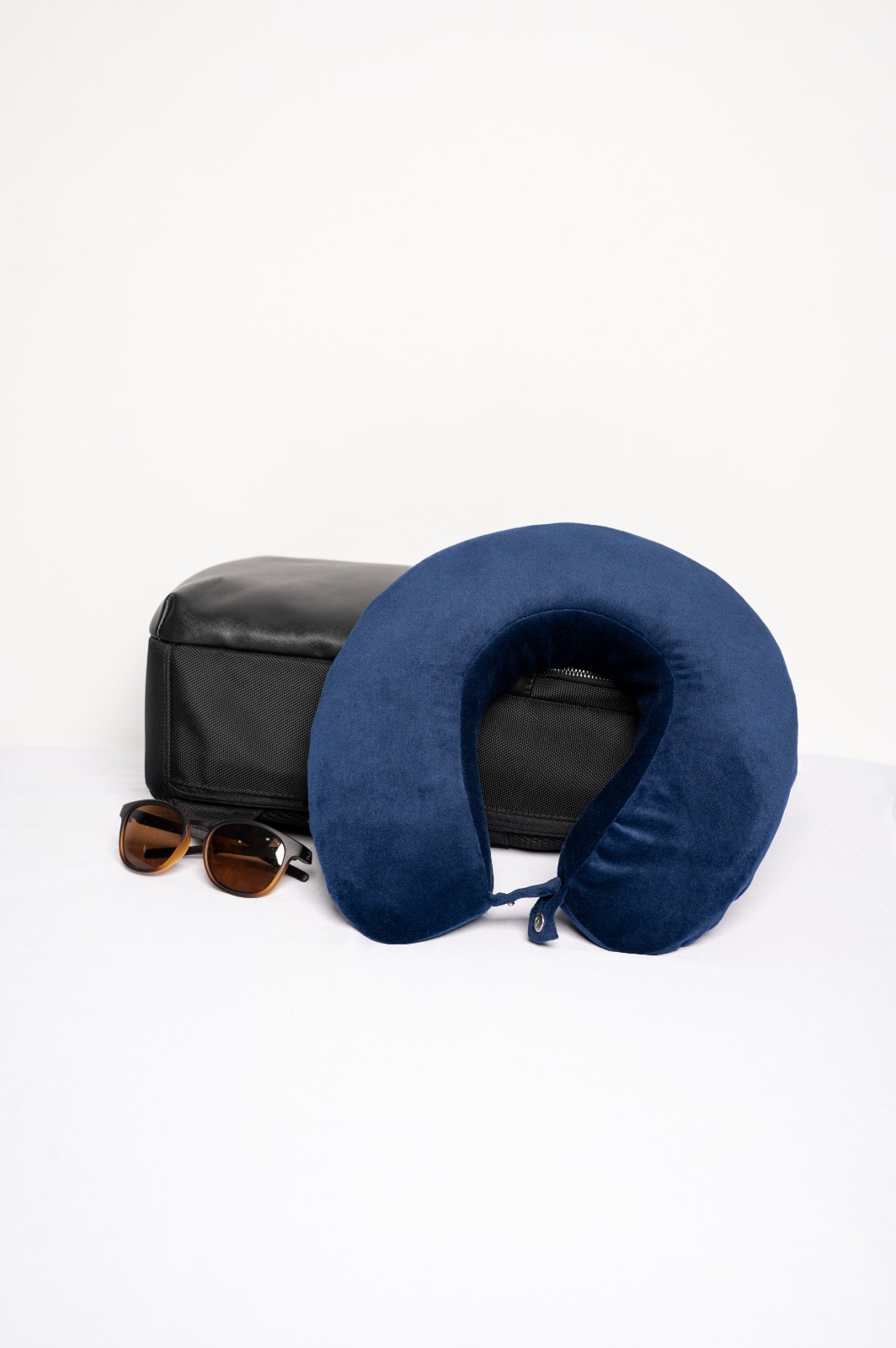Navy travel neck pillow with sunglasses and travel bag